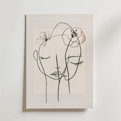 Bozetto Floral Line Faces Poster har minimalistisk svart linjekonst av två ansikten med slutna ögon och delikata blomsterskisser på en ljus beige matt yta, vilket skapar en lugn och intim atmosfär.