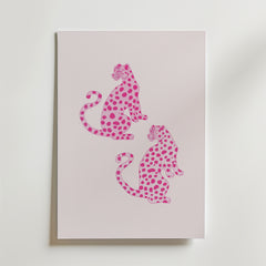 Bozetto Pink Leopard Twins Poster har ett minimalistiskt djurmotiv av två rosa leoparder med mörkare fläckar, som sitter rygg mot rygg på en pastellfärgad bakgrund - perfekt för modern inredning och visas vertikalt på en ljus yta.