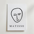 Minimal Matisse Poster by Bozetto har ett minimalistiskt svart linjeansikte på en vit bakgrund med fet "MATISSE" text, tryckt på premiumpapper med en matt finish för en elegant look.