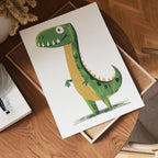 A cheerful green cartoon dinosaur with yellow accents is printed on no-9 white paper, displayed on a wooden table beside a book and chair.