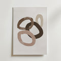 Muted Circles Poster by Bozetto: Abstrakt konsttryck med fyra överlappande ovaler i brunt och beige på vitt, tryckt på FSC-certifierat premiumpapper med en lyxig matt finish för en modern, strukturerad look.