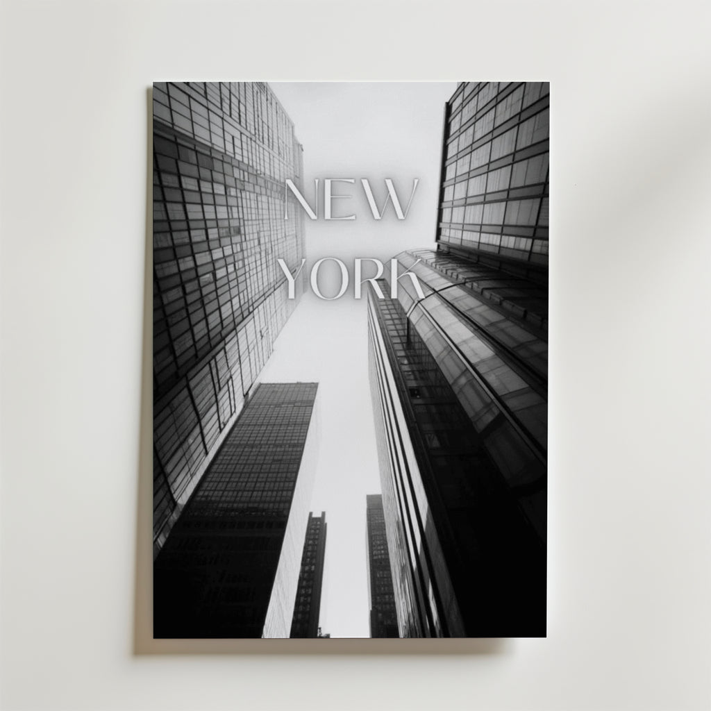 Bozetto New York Poster föreställer svartvita skyskrapor tagna från en låg vinkel med "NEW YORK" i transparenta bokstäver, tryckt på FSC-certifierat premiumpapper för en miljövänlig touch.