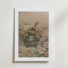 Moët Chandon Poster by Bozetto föreställer en champagneflaska i en utsmyckad ishink, rosa rosor och trädgårdshandskar. Affischen är tryckt på premiumpapper med en lyxig matt finish och visas i en vit ram mot en ljus bakgrund.