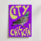 Bozetto Street Pigeon Graphic Poster visar en tecknad duva på en lila bakgrund i pop art-stil, med fet gul "CITY CHICKEN"-text ovanför och under fågeln.