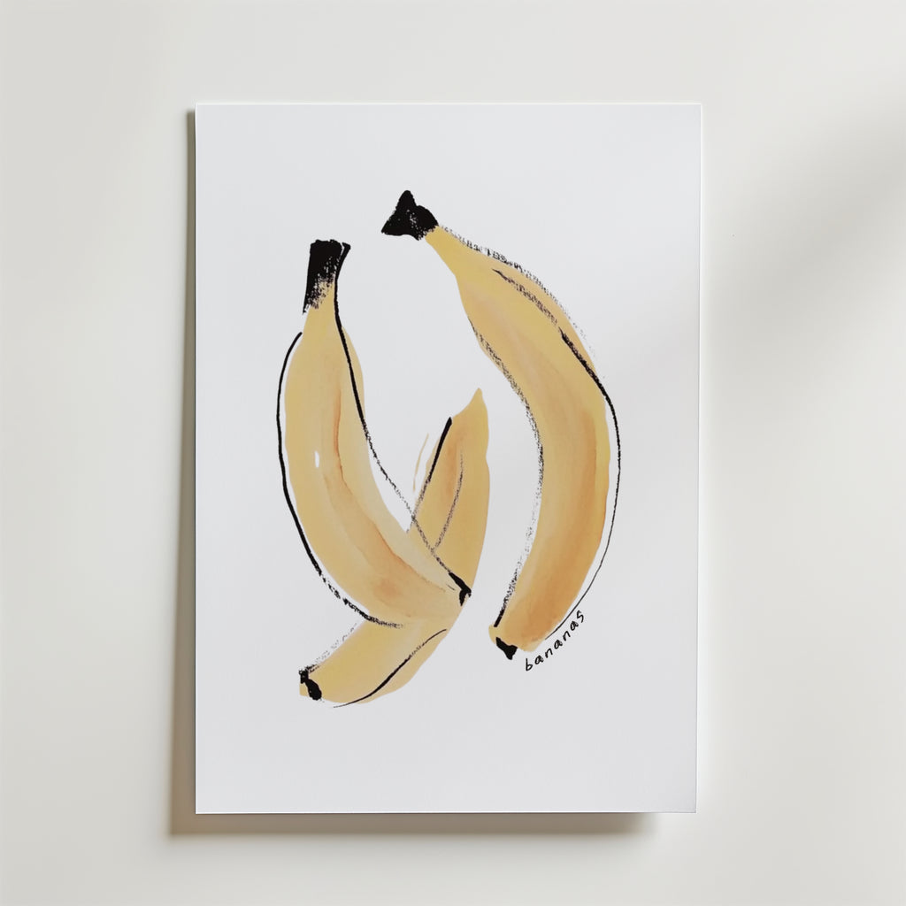 Bozetto Banana Joy Poster visar tre bananer på en vit bakgrund med minimalistiska penseldrag i ljusgult och svart. "Bananas" är handskrivet längst ner till höger, vilket skapar ett unikt konstverk på premiumpapper.