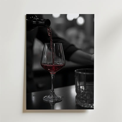 Bozetto Pouring Passion Wine Poster visar rött vin som hälls upp i ett glas på en mörk yta bredvid ett tomt glas, med mjukt suddiga bokeh-ljus som förstärker skönheten i vin i rörelse.