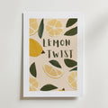 The Lemon Twist Poster by Bozetto är en inramad poster med illustrationer av citronskivor och blad, fet handritad "LEMON TWIST" bokstav, på ljusbeige FSC-certifierat premiumpapper med matt yta.