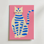 Blue Striped Cat Poster från Bozetto föreställer en krämfärgad katt med blå ränder som sitter upprätt med en alert blick och lång svans på en rosa bakgrund - perfekt för att addera skandinavisk stil till din inredning.