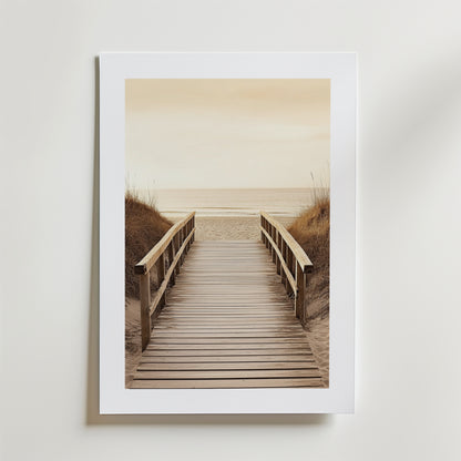 Beach Path Poster by Bozetto föreställer en träpromenad med räcken genom sanddyner mot en lugn strand och hav under en molnig himmel, tryckt på FSC-certifierat premiumpapper med lyxigt matt yta.