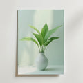 Bozetto Lily Plant In Vase Poster visar en grön bladväxt i en vit vas på en mjukt upplyst bakgrund, tryckt på FSC-certifierat premiumpapper för en ren och elegant stil.