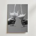 Två händer håller i martiniglas medan mjölkstänk möts i luften. Cheers Martini Drink Poster från Bozetto har denna slående svartvita bild på premiumpapper, vilket gör den perfekt för modern inredning med sin släta bakgrund.
