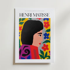 Bozetto Madame Rouge Matisse Poster har en livfull illustration av en mörkhårig kvinna i profil, utsmyckad i djärva färger med en ljus, blommig bakgrund som utstrålar kvinnlig styrka.