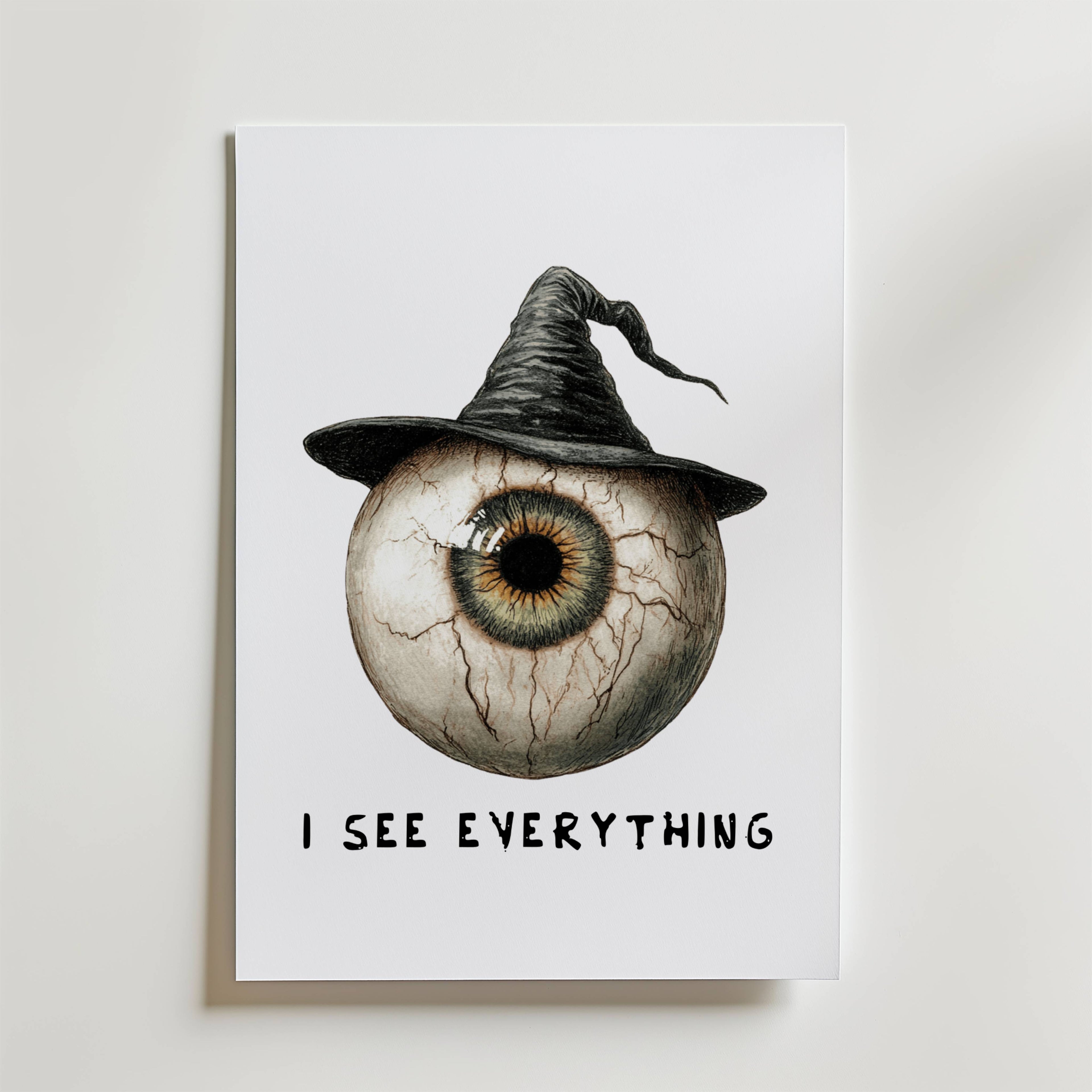 Bozetto I See Everything Poster föreställer en stor ådrig ögonglob i en häxhatt som blandar mörk elegans. "I SEE EVERYTHING" står under, vilket gör denna unika öga poster perfekt för effektfulla väggdekor på en vit bakgrund.