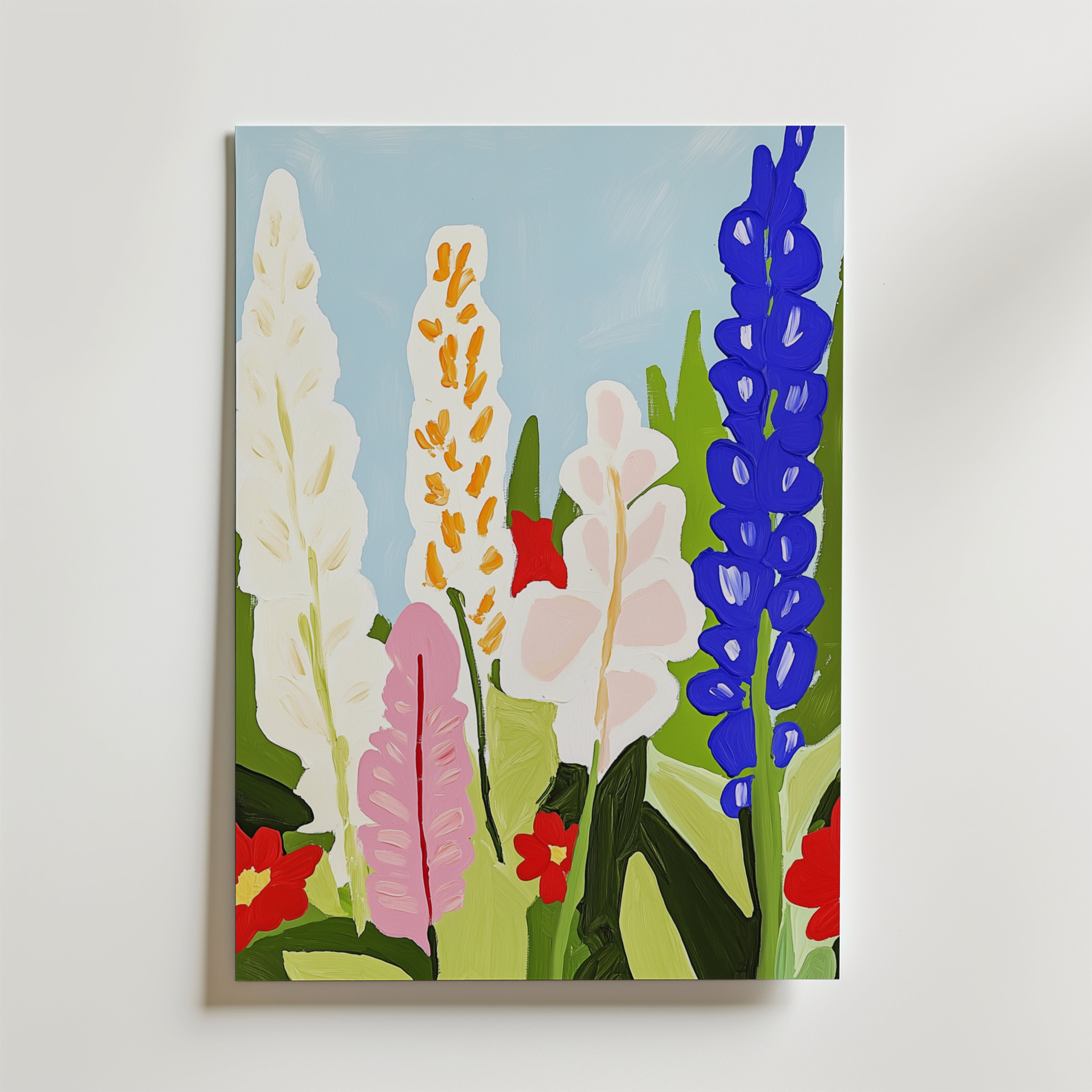 Floral abstract vibrant botanical Poster by Bozetto föreställer höga, stiliserade blommor i vitt, rosa och blått med gröna blad och röda blommor på en ljusblå himmel, tryckt på FSC-certifierat premiumpapper och uppsatt på en vit vägg.