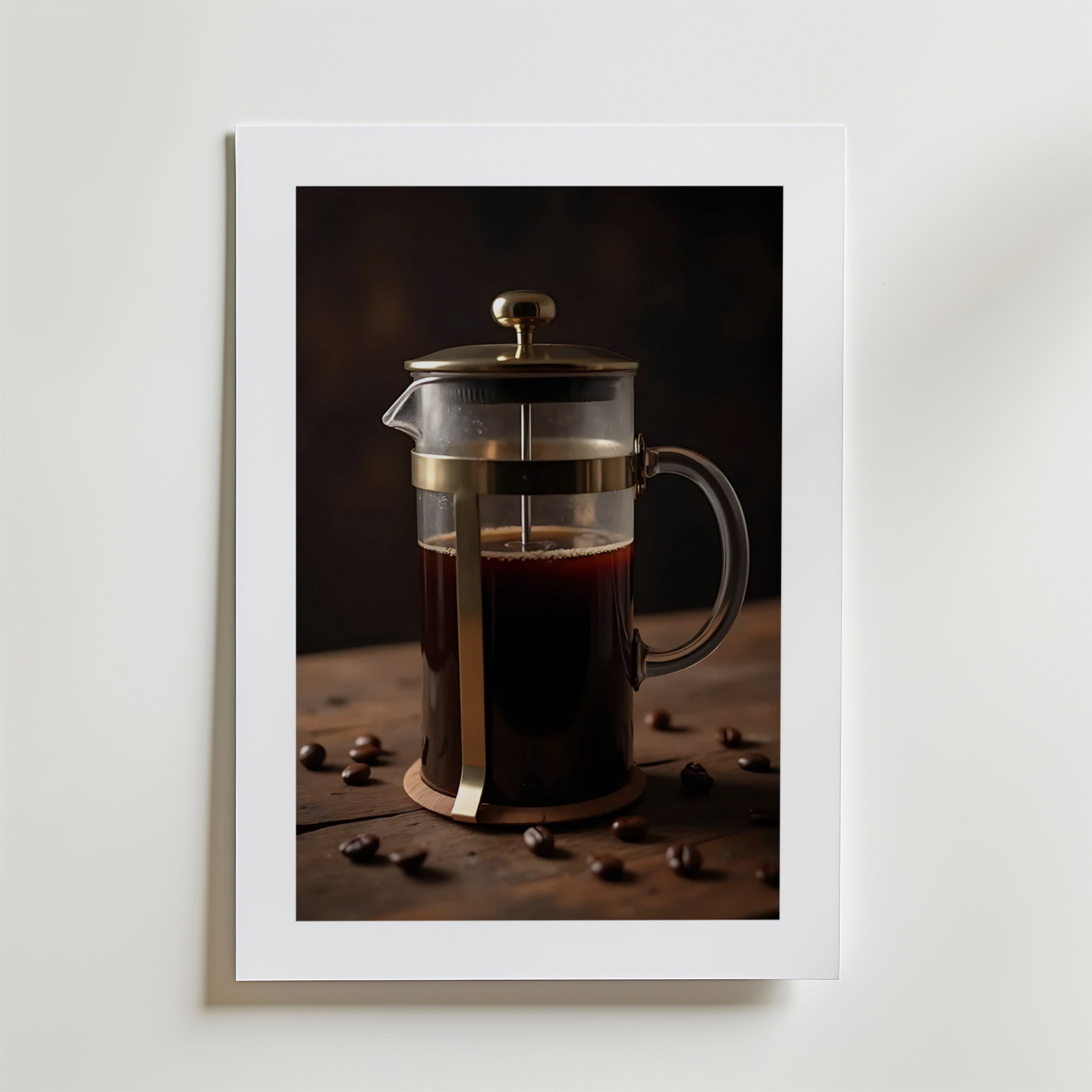 Coffee Press Poster by Bozetto föreställer en fransk press fylld med kaffe på en träyta med utspridda bönor, mot en mörk bakgrund. Den rika texturen och den matta finishen skapar en raffinerad, modern look.