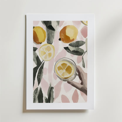 Bozetto Zesty Moment Poster föreställer akvarellfärgade citroner, skivor, gröna blad och en hand med en citrondrink på en mjuk rosa och vit mönstrad bakgrund, tryckt på högkvalitativ poster premiumpapper.