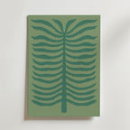Quiet Palm Poster från Bozetto föreställer en minimalistisk stiliserad ormbunke med mörkgröna symmetriska grenar på en dovt grön bakgrund, inramad och placerad mot en ljus vägg.