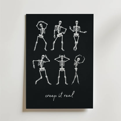 Bozetto Dancing Bones Poster visar sex vita skelett som dansar på en svart bakgrund, med "creep it real" i lekfull kursiv under, och blandar humor och kusliga vibbar perfekt för Halloween.
