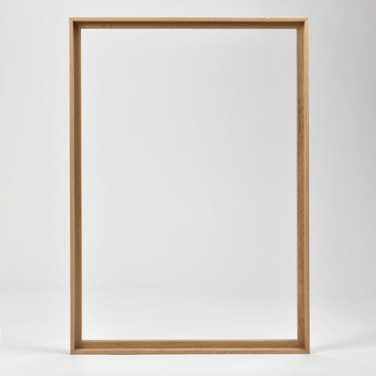 Bozetto Canvas Träram Ek är en enkel, tom tavelram i trä med en exklusiv träram, som står upprätt mot en vit bakgrund.