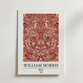 Bozetto William Morris Bird Poster visar Morris konstverk "Bird" från 1869 - två stiliserade fåglar bland intrikata blomstermotiv i rött, guld och beige, som blandar naturmotiv med tidlös inredning. Konstnärens namn och detaljer finns nedan.