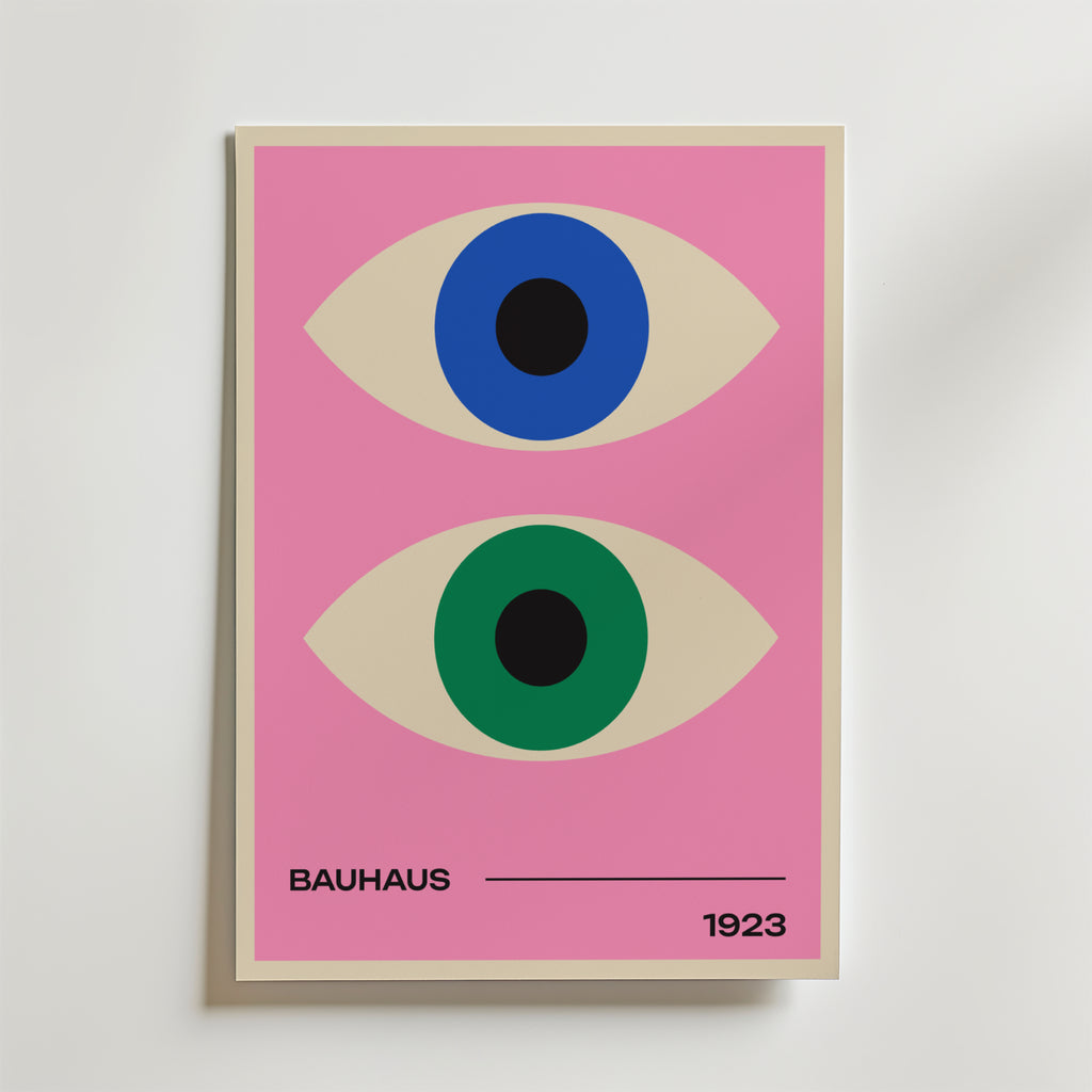 Bauhaus Dual Vision Poster by Bozetto föreställer två stiliserade ögon - ett blått och ett grönt - på en rosa bakgrund med "BAUHAUS" till vänster och "1923" till höger, åtskilda av en svart linje längst ner.