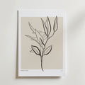 Botanical Breath Poster by Bozetto har en enkel svart linjeteckning av en bladig gren på beige, accentuerad av en vit matt kant och subtil BOTANICAL GALLERY text längst ner till vänster, vilket framkallar tidlös harmoni.